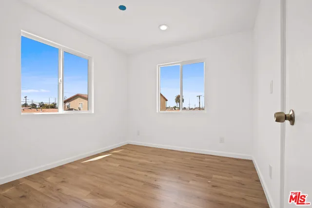 a view of an empty room with wooden floor