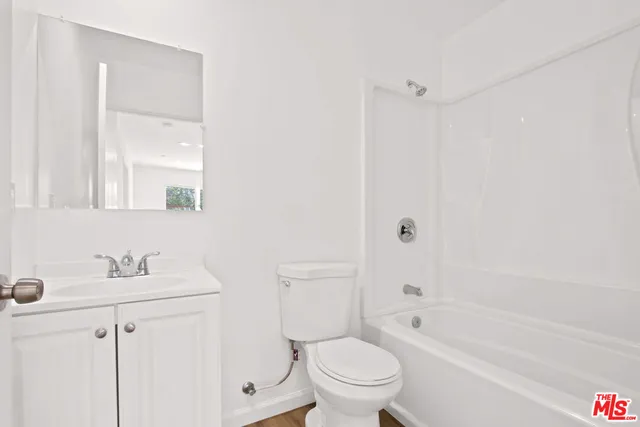 a kitchen with cabinets stainless steel appliances and wooden floor