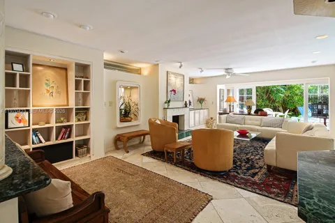 a living room with furniture a fireplace and a floor to ceiling window