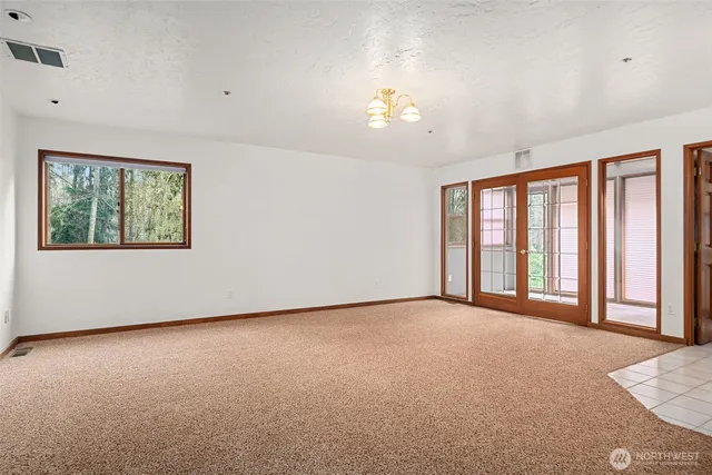 a view of an empty room with window and cabinet