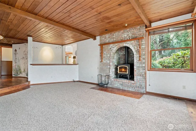 a view of an empty room with a fireplace and a window