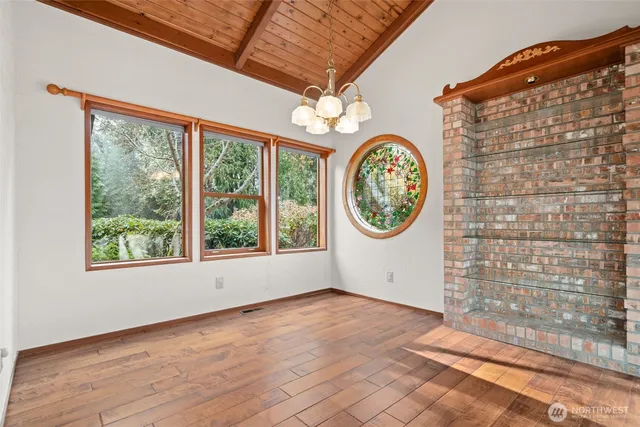 a view of a hallway with entryway wooden floor and a chandelier