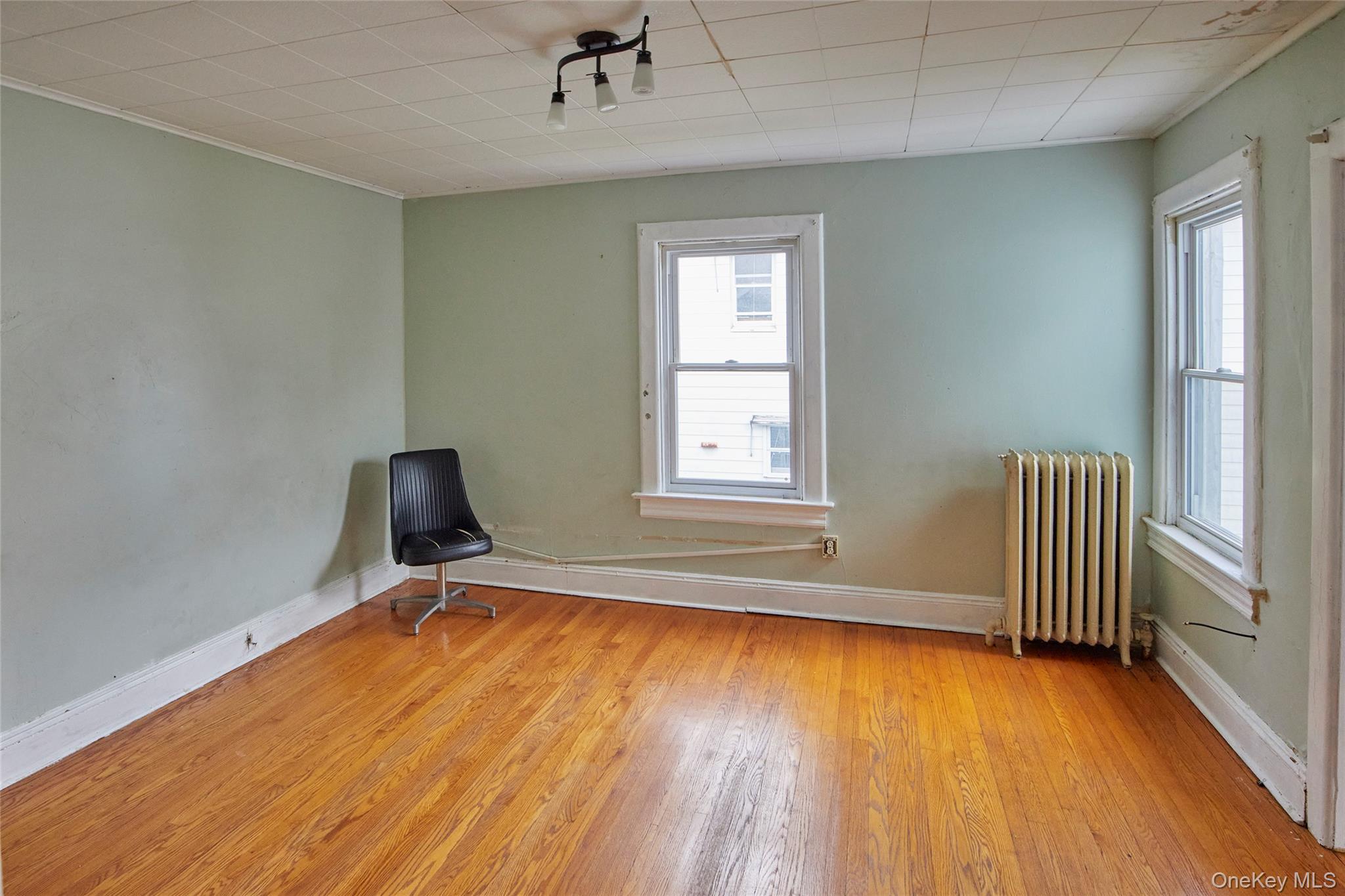728 Frost Avenue Peekskill, NY 10566 - Photo 13 of 18 a view of an empty room with a window and wooden floor