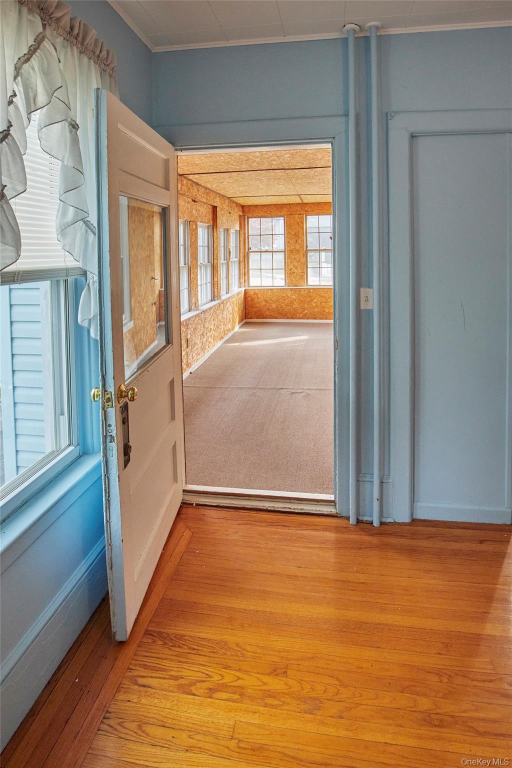 728 Frost Avenue Peekskill, NY 10566 - Photo 8 of 18 an empty room with wooden floor and windows