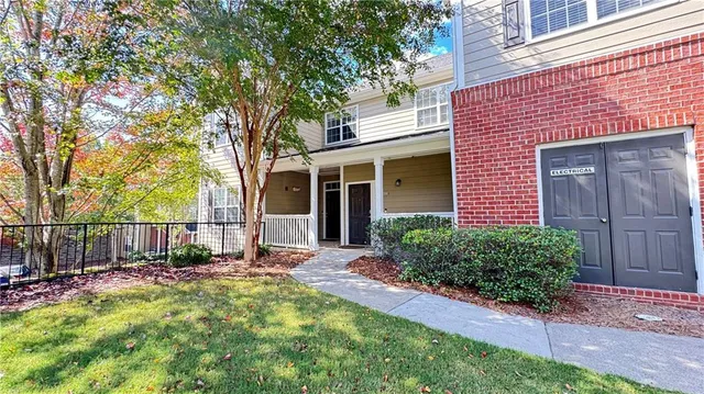 a view of a house with a yard and potted plants