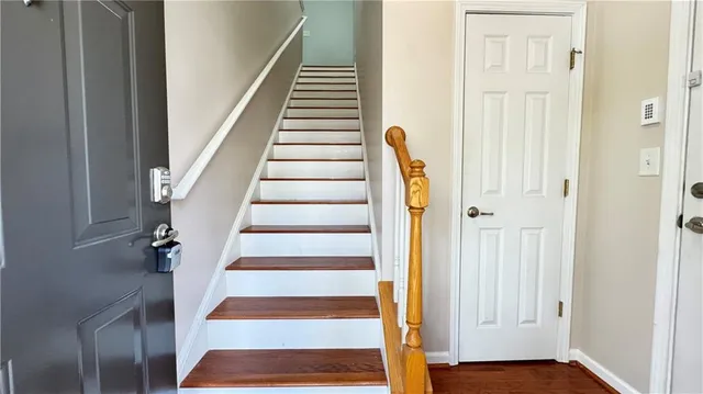 a view of staircase with wooden floor and white walls
