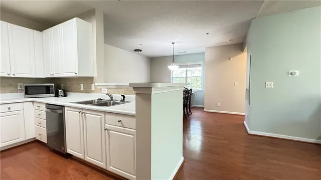 a kitchen with a sink a stove a refrigerator and cabinets