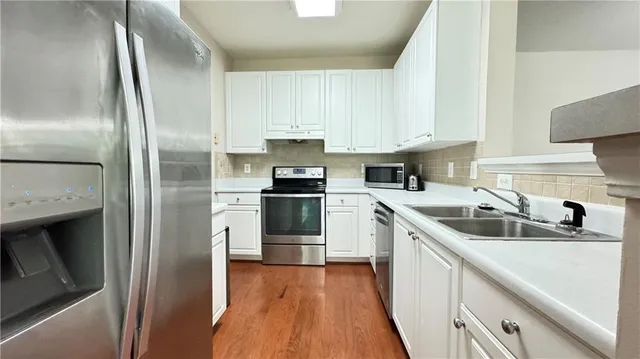 a kitchen with a sink cabinets and stainless steel appliances