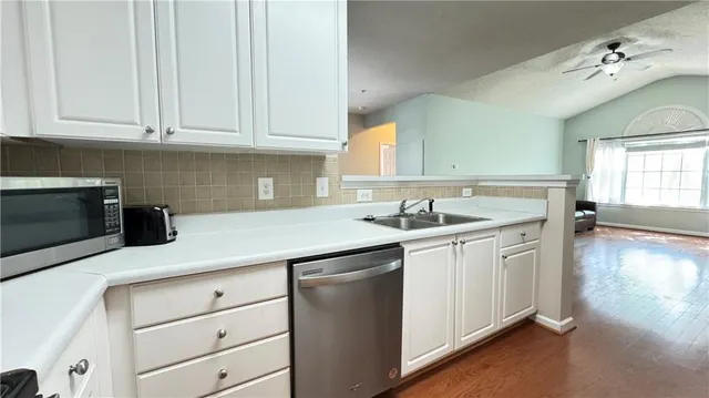 a kitchen with stainless steel appliances granite countertop a sink stove and cabinets