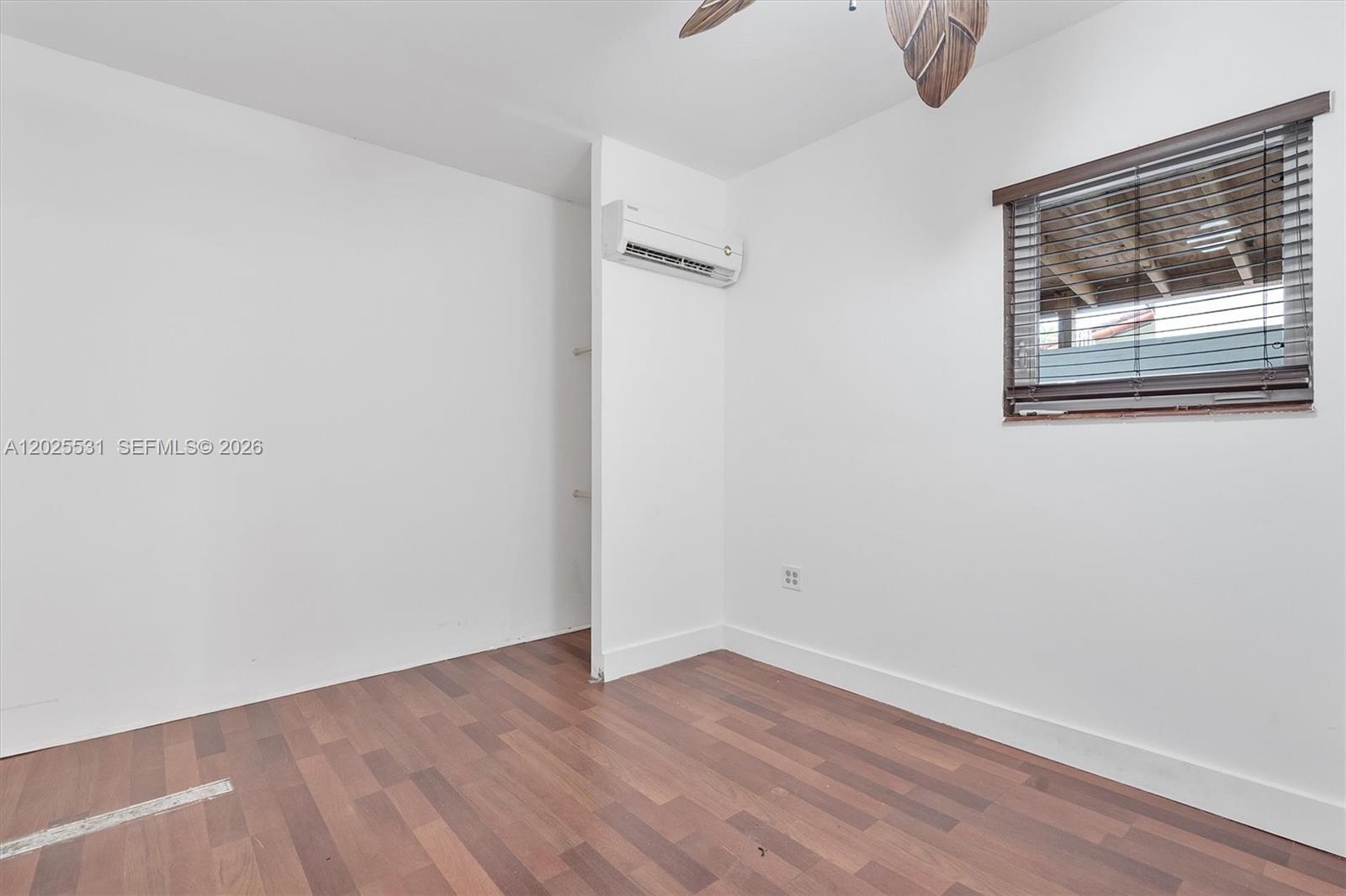 3951 Southwest 2nd Terrace, Unit 3951 Miami, FL 33134 - Photo 16 of 21 a view of an empty room with wooden floor and a window