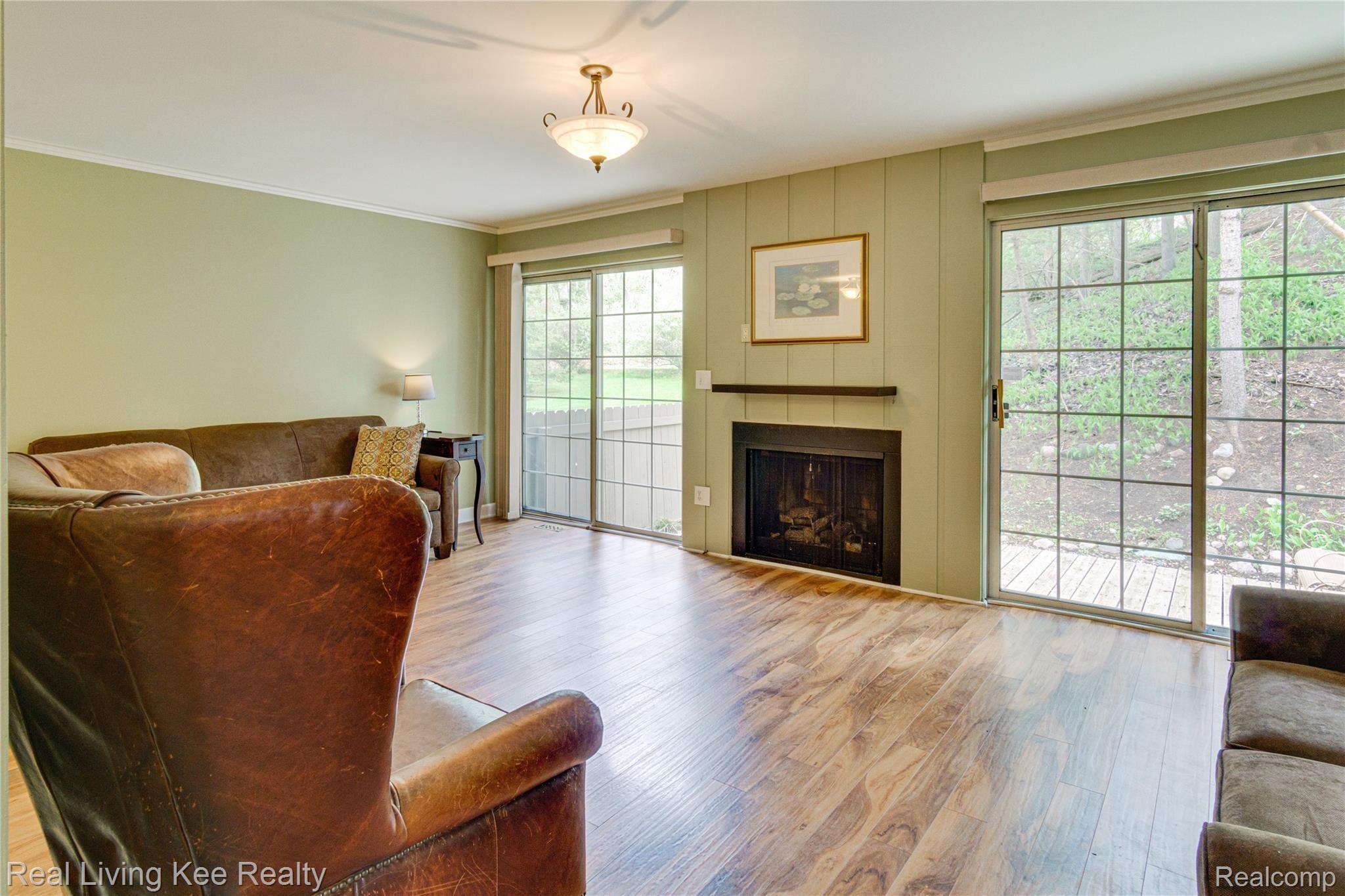 1590 Ravine Lane, Unit 171 Rochester, MI 48306 - Photo 4 of 22 Spacious Great Room with gas fireplace, two-doorwalls that open to the large deck and a beautiful view of the woods.