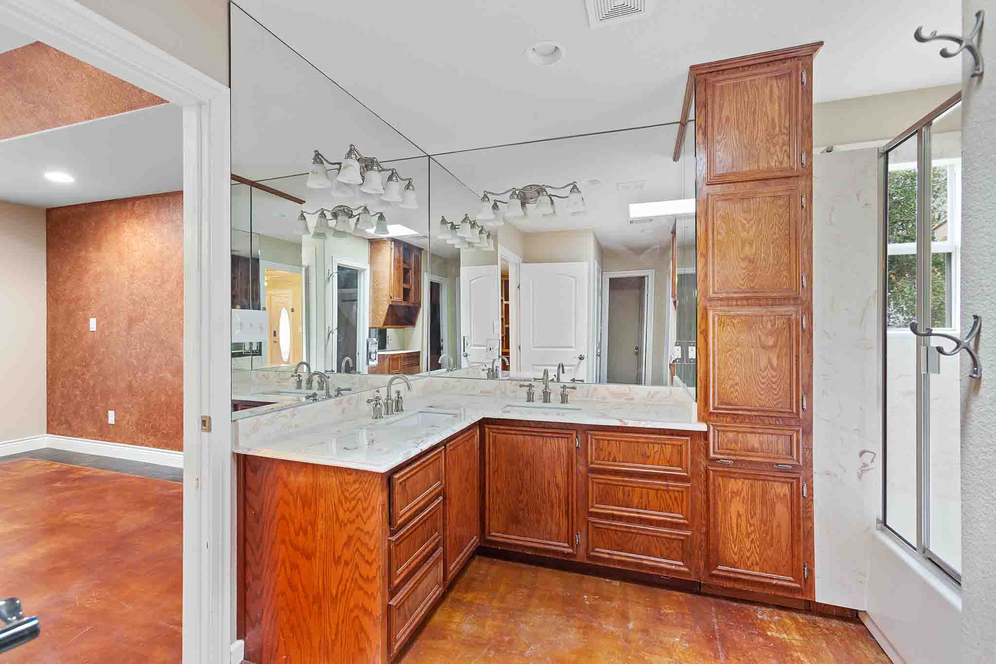 4525 Bell Springs Road Dripping Springs, TX 78620 - Photo 20 of 39 a bathroom with a granite countertop sink a mirror and shower