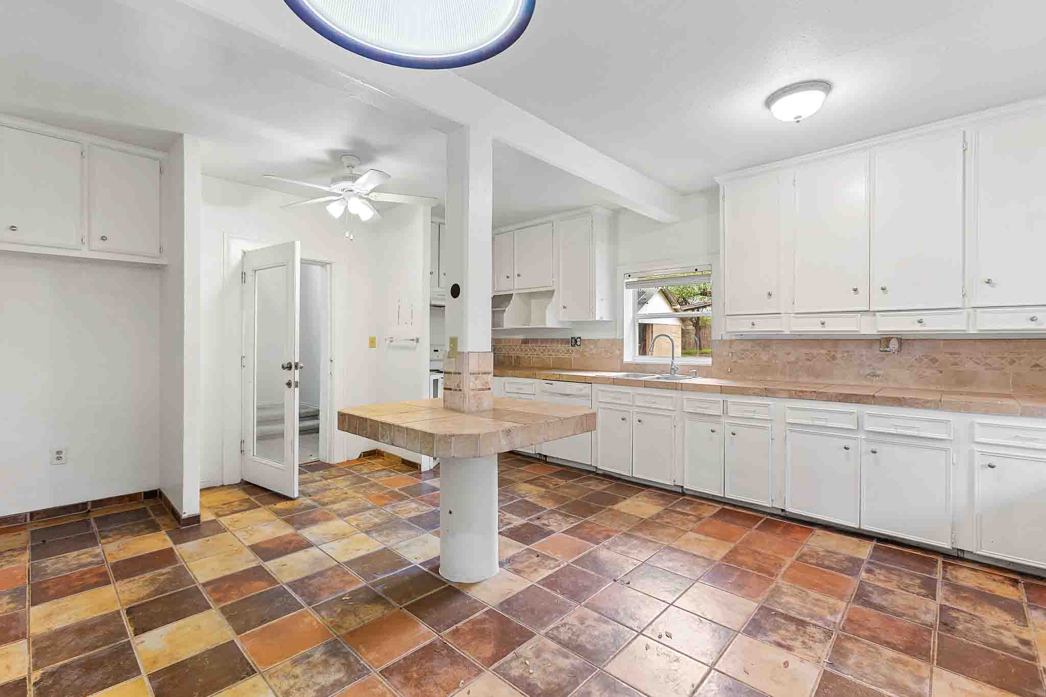 4525 Bell Springs Road Dripping Springs, TX 78620 - Photo 29 of 39 a kitchen with a checkered floor and white cabinets