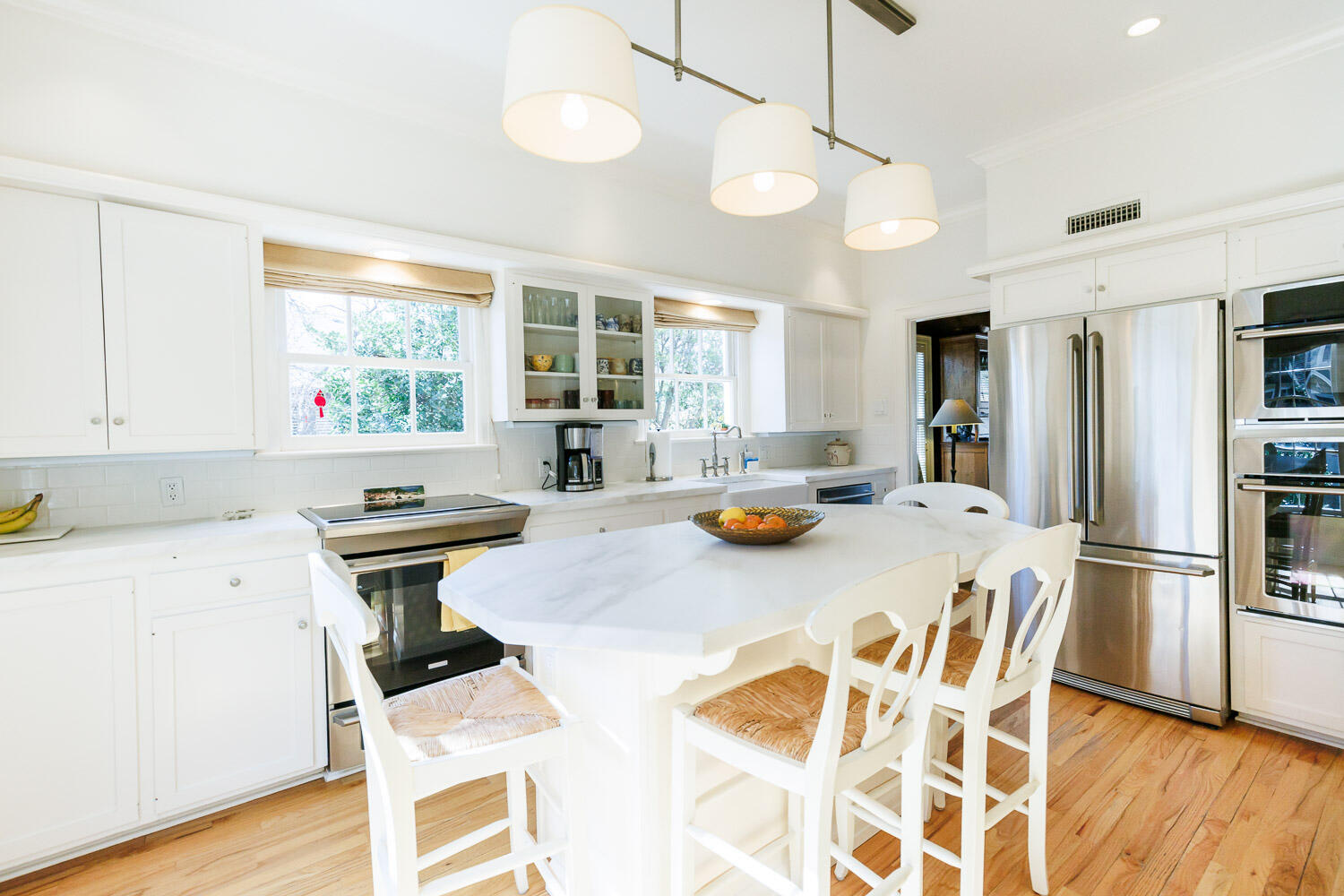 2607 22nd Street Lubbock, TX 79410 - Photo 13 of 87 a kitchen with a refrigerator a stove a sink dishwasher and a dining table with wooden floor