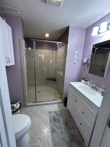 a bathroom with a double vanity sink toilet mirror and shower
