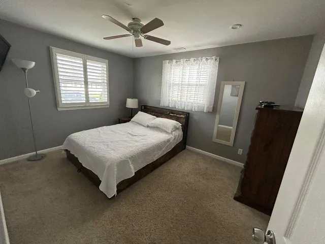 a bedroom with a bed next to a window