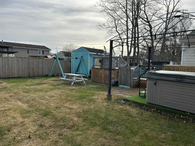 a view of backyard with barbeque grill and wooden fence