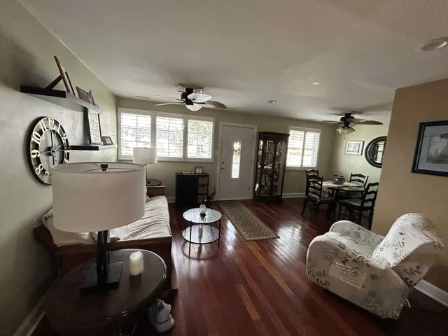 a living room with furniture a dining table and wooden floor