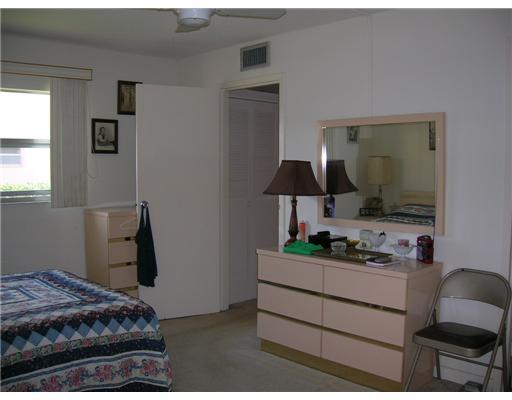 447 Saxony Way, Unit 447 Delray Beach, FL 33446 - Photo 6 of 7 a bedroom with a bed and a mirror