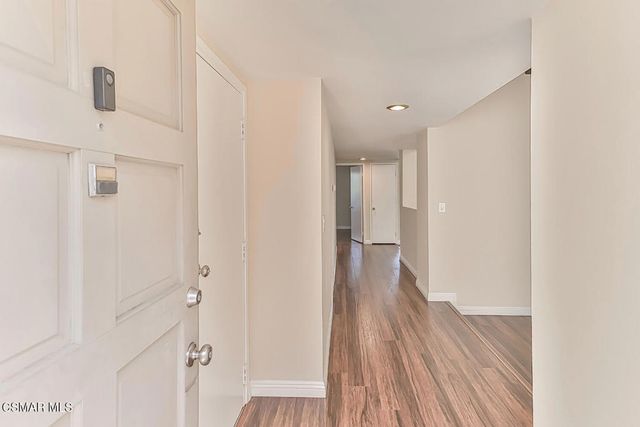a kitchen with granite countertop a sink and dishwasher with wooden floor