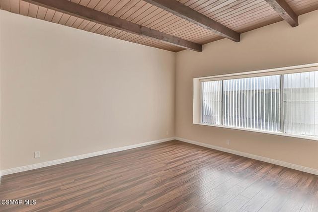 a kitchen with wooden floors and white stainless steel appliances