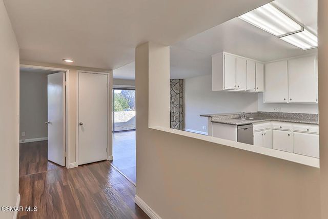 a view of a kitchen with a stove refrigerator and wooden floor