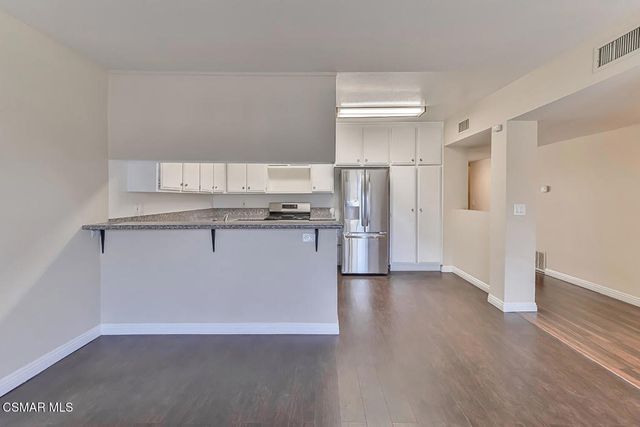 a kitchen with a refrigerator sink and cabinets