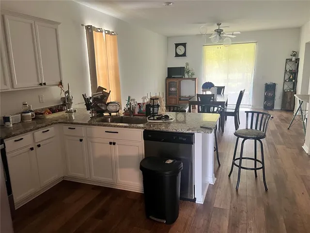 a kitchen with a sink cabinets and wooden floor