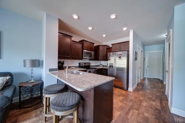 a kitchen with refrigerator and chairs