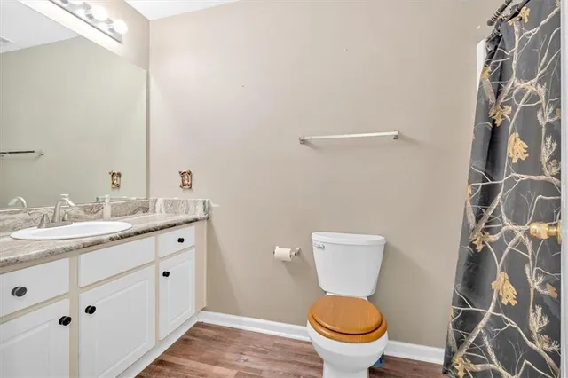 a bathroom with a granite countertop toilet sink and a mirror