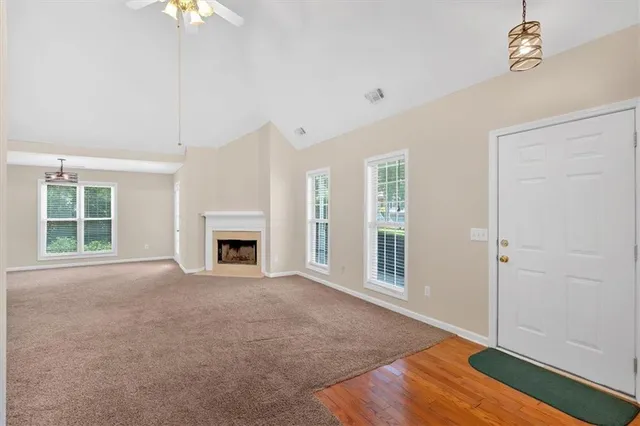 a view of an empty room with a window and fireplace
