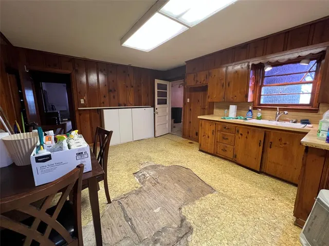 a kitchen with a table chairs sink and wooden floor