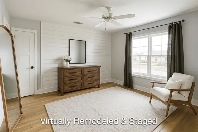 a spacious bedroom with a bed a table and chair