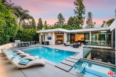 a view of a house with swimming pool and sitting area