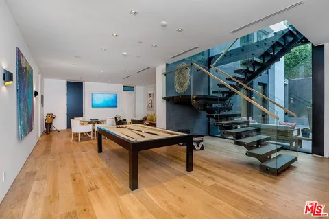 a living room with furniture ceiling fan and a wooden floor