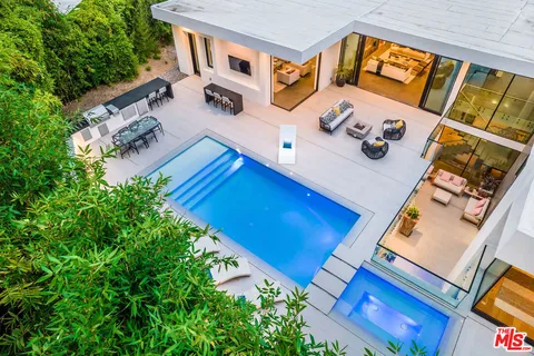 a view of a house with swimming pool and sitting area