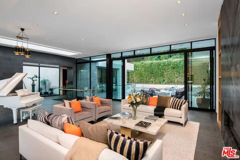a living room with furniture and floor to ceiling windows