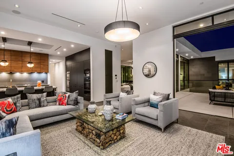 a living room with furniture a rug and a large mirror