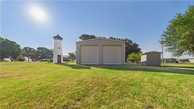 a view of a house with a yard and a large tree