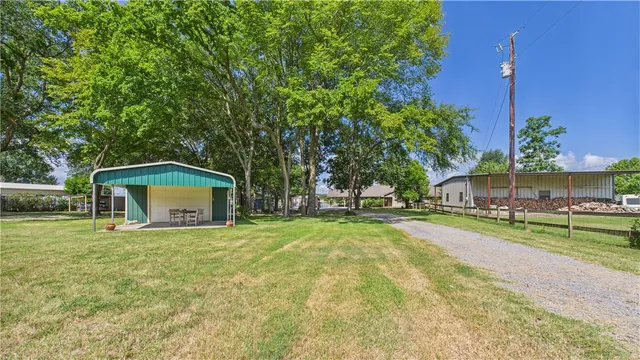 a view of a house with a yard and large trees