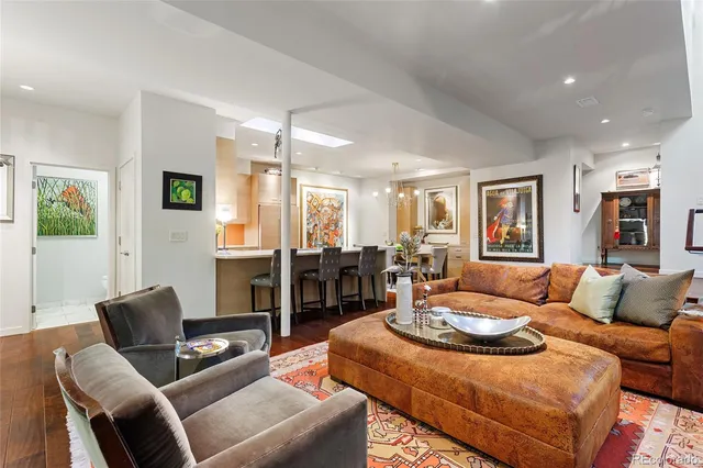 a living room with furniture a flat screen tv and a dining table