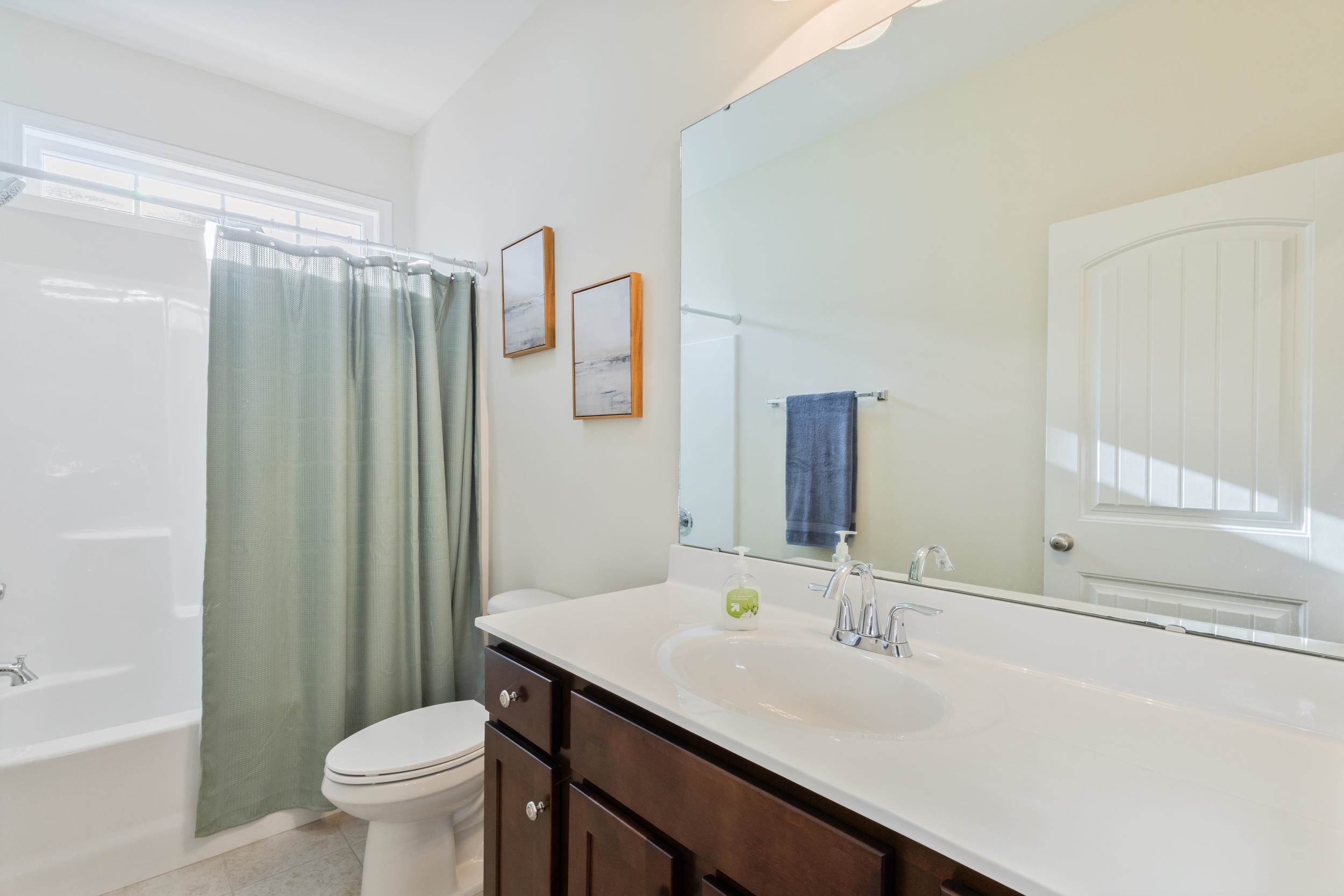 224 Obi Lane Surfside Beach, SC 29575 - Photo 11 of 24 Kitchen featuring appliances with stainless steel finishes, light stone counters, dark wood-style flooring, and dark brown cabinetry