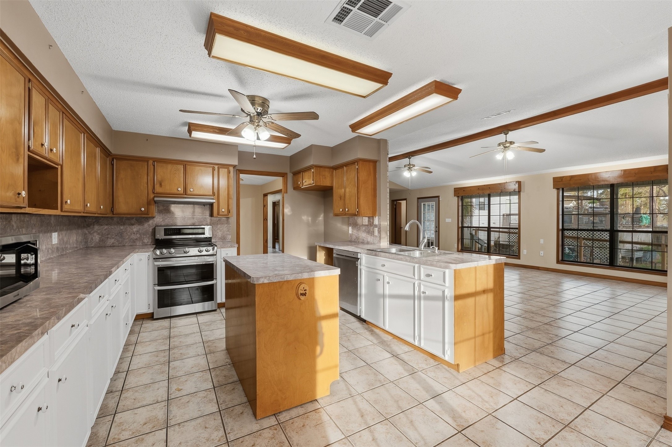 200 Cove View Drive Trinity, TX 75862 - Photo 7 of 39 a kitchen with stainless steel appliances granite countertop a stove top oven a refrigerator a sink and dishwasher with white cabinets