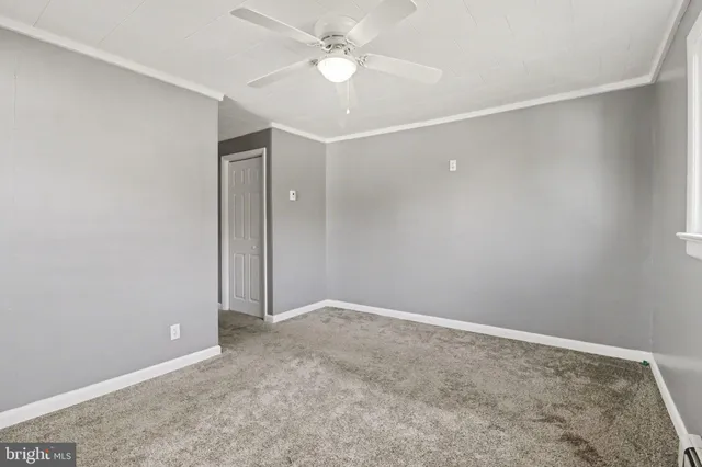 an empty room with a ceiling fan and a window