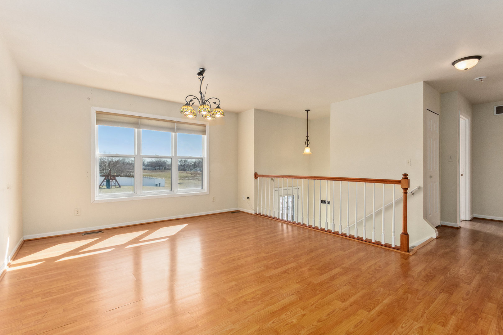 415 Davidson Drive Minooka, IL 60447 - Photo 3 of 18 a view of an empty room with wooden floor and a window