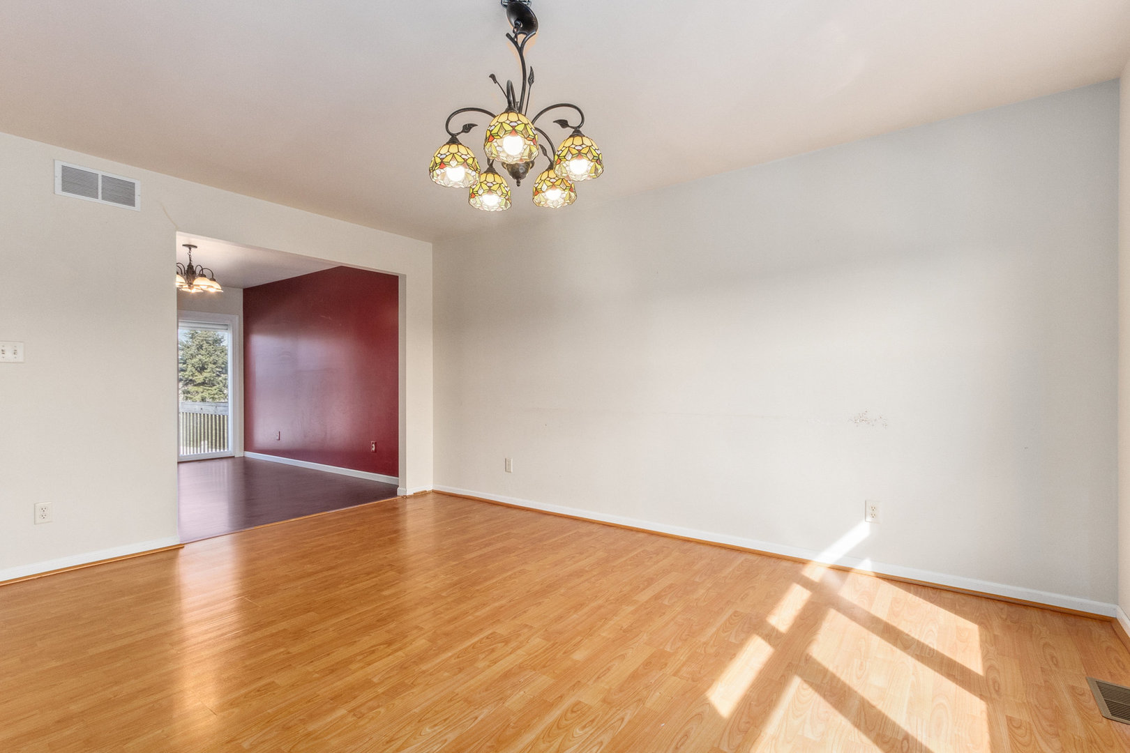415 Davidson Drive Minooka, IL 60447 - Photo 4 of 18 a view of an empty room with chandelier and wooden floor