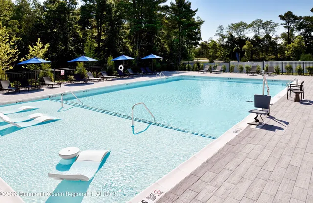 a view of a swimming pool with a patio and trees