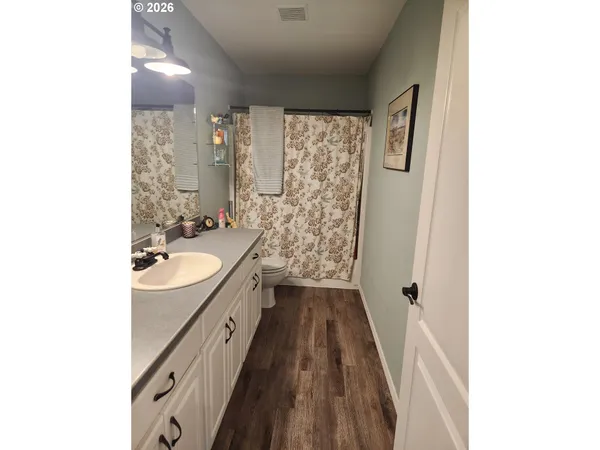 a spacious bathroom with a granite countertop sink a mirror and a shower