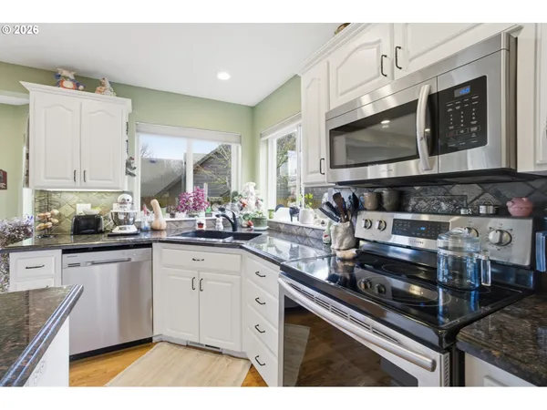 a kitchen with stainless steel appliances kitchen island granite countertop a stove a sink and a microwave