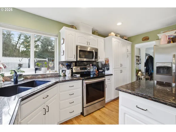 a kitchen with granite countertop a sink stainless steel appliances and counter space